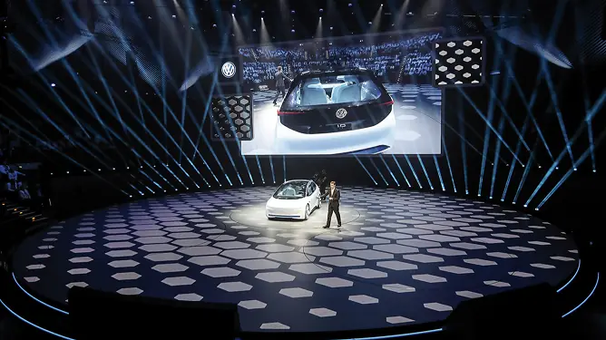 Car on a stage under light beams