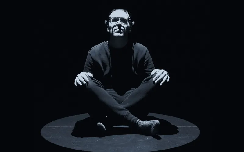 A man sitting cross-legged in a circle of light